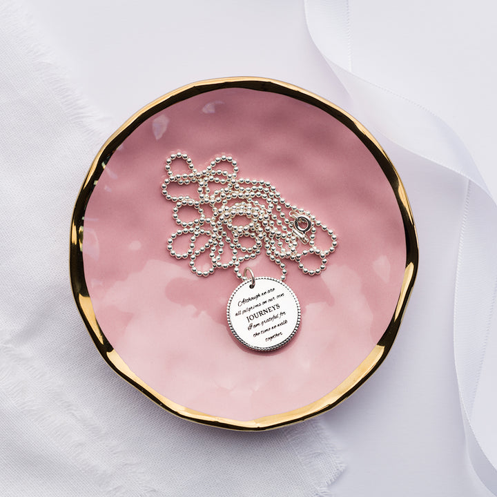 Although we are all pilgrims on our own journeys charm on a pink plate