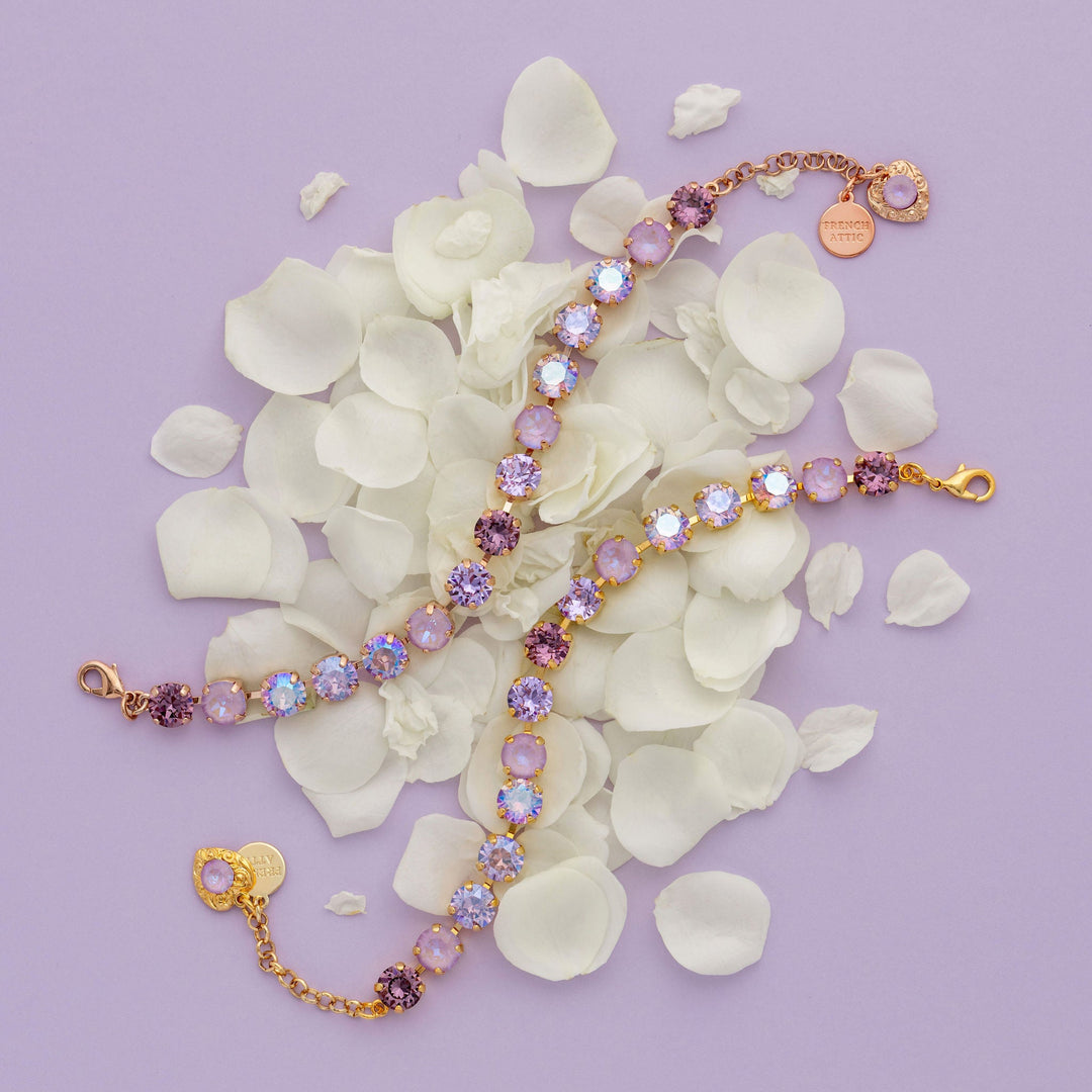 Bracelets with purple and gold accents on white petal background