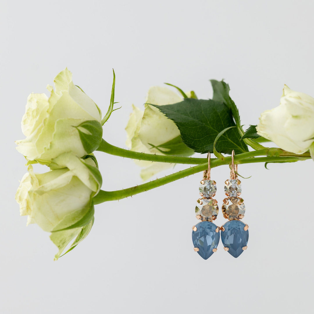 Pair of earrings with blue crystals on a branch of white roses.